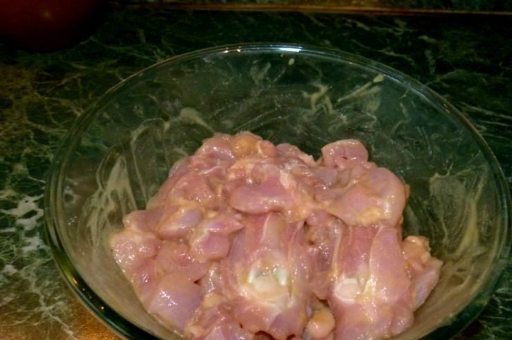 1. Этап. Плов в духовке с курицей: Перекладываем нарезанную курицу в миску, добавляем горчицу и немного соли, хорошенько перемешиваем.