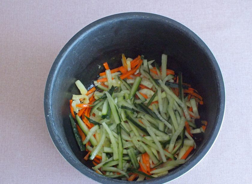 1. Этап. Фунчоза в мультиварке: С огурцов слейте выделившийся сок. Добавьте огурцы в чашу мультиварки. Прогревайте помешивая 3 минуты.