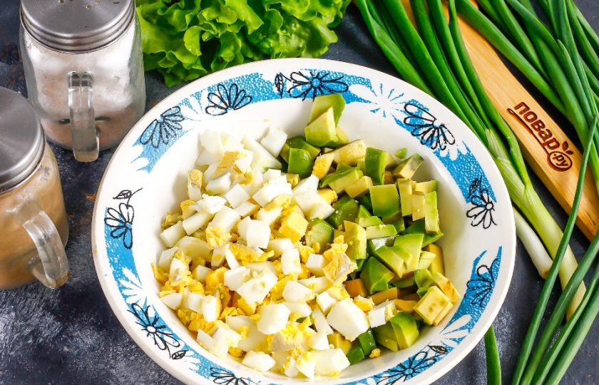 1. Этап. Салат из авокадо с курицей: Очистите авокадо от кожуры, удалите косточку и нарежьте мякоть мелкими кубиками. Также нарежьте и куриные яйца. Выложите обе нарезки в салатник или глубокую емкость.