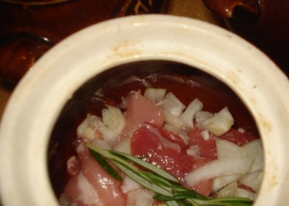 1. Этап. Свинина запеченная в горшочке: Затем мы натираем каждый горшочек небольшим количеством масла и укладываем в него мясо и лук. Добавляем специи и зелень по вкусу.