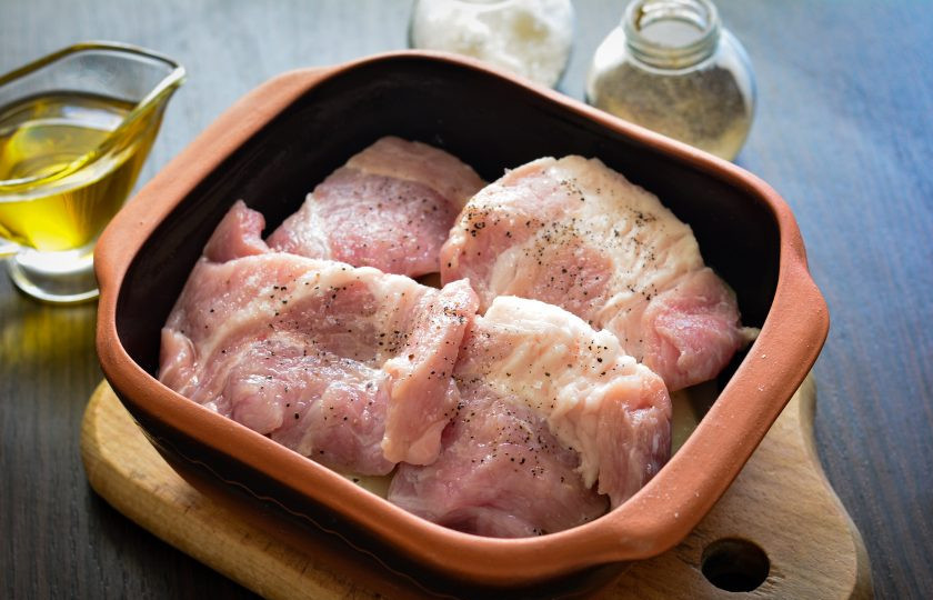 1. Этап. Свиная лопатка с картошкой в духовке: Свиную лопатку вымойте, просушите салфетками и нарежьте слайсами-кусочками. Выложите кусочки лопатки поверх картофеля в форму. Присыпьте мясо солью и перцем по вкусу.