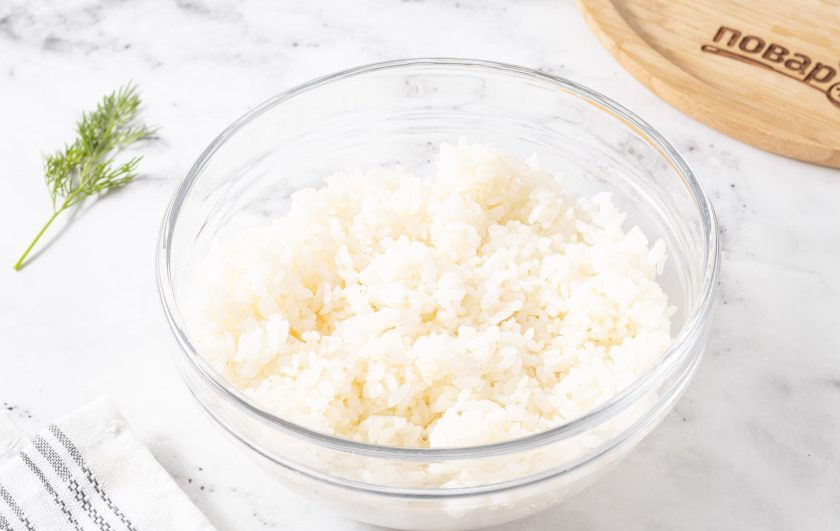 1. Этап. Онигири с огурцом: Рис промойте до прозрачности. Залейте чистой водой, доведите до кипения, перемешайте. Убавьте огонь на минимум, варите 15 минут под крышкой. Затем накройте кастрюлю чистым полотенцем и сверху крышкой, оставьте еще на 15 минут. Немного остудите рис, добавьте рисовый уксус, соль и сахар, перемешайте.