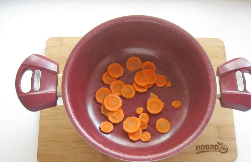 1. Этап. Скумбрия в томате с овощами: Морковь очистите, помойте и нарежьте. Выложите в кастрюлю с толстым дном.