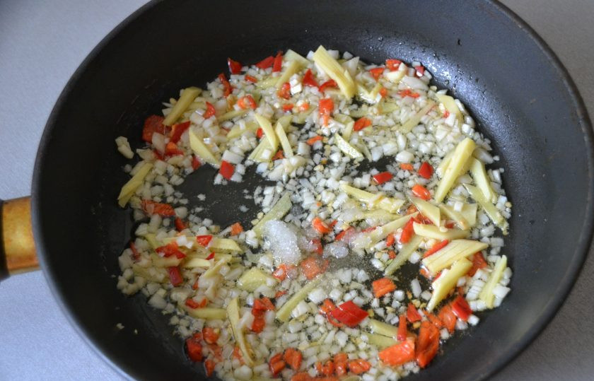 1. Этап. Кальмары в чесночном соусе: В разогретую сковороду добавьте немного растительного масла, выложите смесь чеснока, перца и имбиря. Всыпьте чайную ложку сахара, обжарьте пару минут.