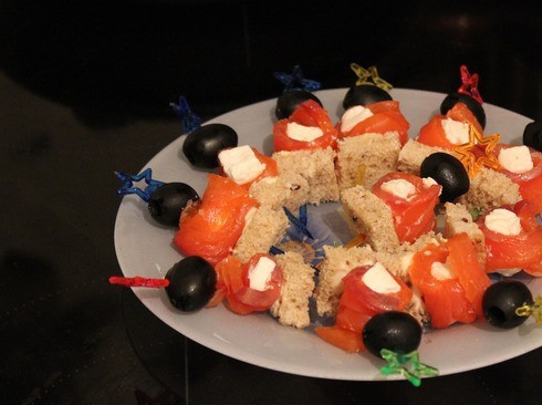 1. Этап. Канапе с колбасой и сыром: 4. Делаем второй вид канапе - кусочки семги смазываем плавленным сыром, сворачиваем рулетом, и нанизываем на кусочки хлеба вместе с маслинами.