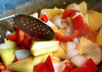 1. Этап. Говядина с ананасом: 6. В глубокой сковороде разогрейте 70 граммов растительного масла. В кипящее масло положите все овощи вместе с кусочками ананаса. Быстро помешивая, обжарьте на большом огне 5 минут.