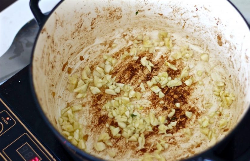 1. Этап. Говядина в вине в духовке: 6. Верните кастрюлю на огонь, влейте 1-2 столовые ложки растительного масла, тем временем очистите и нарежьте чеснок, выложите его в кастрюлю.