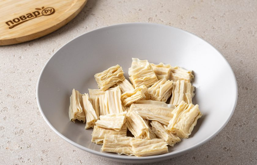 1. Этап. Салат из соевой спаржи с огурцом: Спаржу предварительно замочите в воде на ночь. Затем промойте, тщательно отожмите и нарежьте на небольшие ломтики.