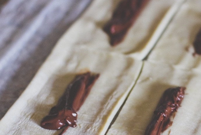 1. Этап. Слойки с шоколадно-ореховой пастой: 2. Выложите в центр каждого прямоугольника около 1 чайной ложки шоколадно-ореховой пасты, распределив ее вдоль.