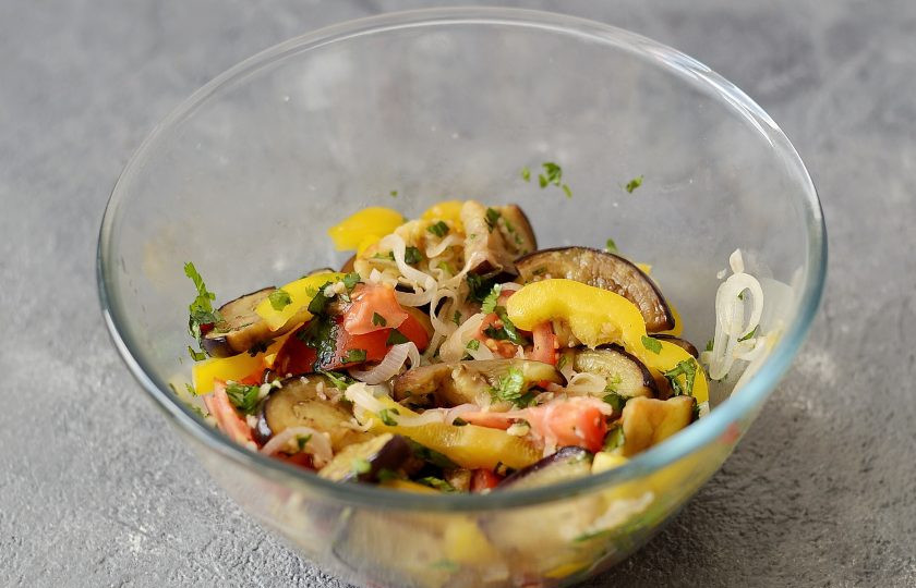 1. Этап. Салат с баклажанами по-армянски: Соедините все овощи в одной миске, посолите и поперчите по вкусу. Добавьте зелень, чеснок и острый перец. Перемешайте и оставьте салат настояться на 10-15 минут.