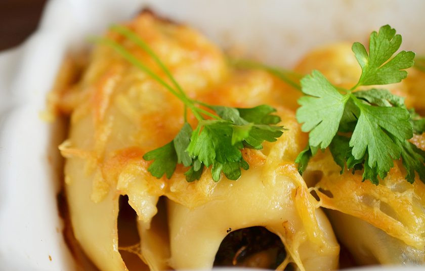 1. Этап. Кальмары, фаршированные грибами и черносливом: Присыпьте сверху сыром и запекайте в разогретой до 180 градусов духовке 30 минут. Перед подачей украсьте зеленью.