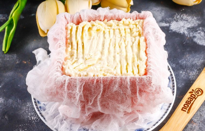 1. Этап. Легкая пасха: Застелите форму двойным слоем марли, чтобы концы свисали на тарелку. Выложите в форму творожную массу и утрамбуйте.