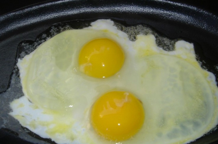 1. Этап. Яичница с шампиньонами и помидорами: На другой сковороде растапливаем оставшееся сливочное масло и разбиваем на сковороду яйца, готовим их под крышкой на медленном огне.