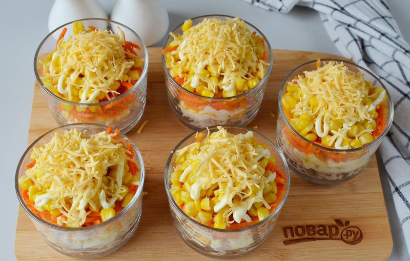 1. Этап. Новогодний слоеный салат: Украсьте салат тертым сыром, добавьте зелень по желанию.