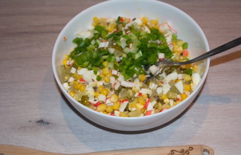 1. Этап. Легкий салат с крабовыми палочками: Добавьте в салатник измельченную зелень. Заправьте салат майонезом.