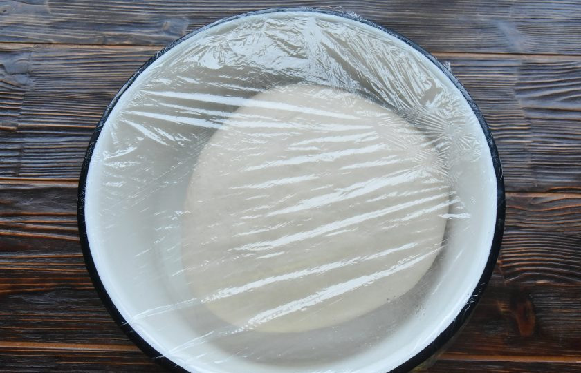 1. Этап. Пигоди по-корейски: Переложите полуфабрикат на поверхность столешницы и продолжите замес теста. Чем дольше его замешивать, тем активнее освобождается клейковина. Тесто становится мягким и эластичным. Переложите округленную заготовку в миску, слегка смазанную растительным маслом. Накройте миску пищевой пленкой и оставьте в теплом месте для подъема.