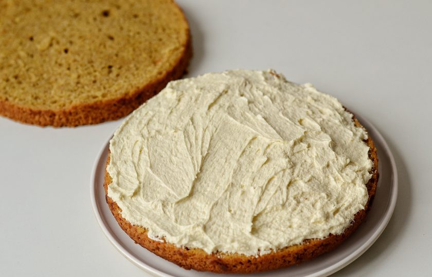 1. Этап. Постный морковный торт: Промажьте нижний корж половиной крема, накройте верхним.