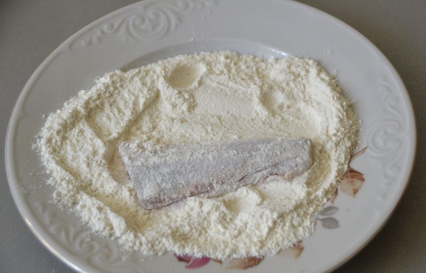 1. Этап. Терпуг, жареный на сковороде: Поставьте сковороду на огонь, влейте растительное масло, разогрейте. Обваляйте кусочек рыбы в муке.