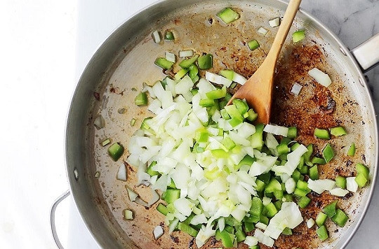 1. Этап. Рис с сосиской: 3. Добавьте еще чуточку масла при необходимости и отправьте на сковороду измельченный лук и перец. На среднем огне жарьте, помешивая, до золотистого цвета.