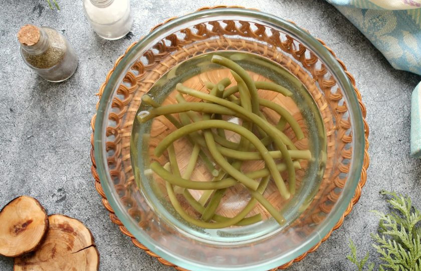 1. Этап. Папоротник с курицей: Соленый папоротник замочите в холодной воде на 4 часа, чтобы удалить лишнюю соль. Затем достаньте из воды и разрежьте на части.