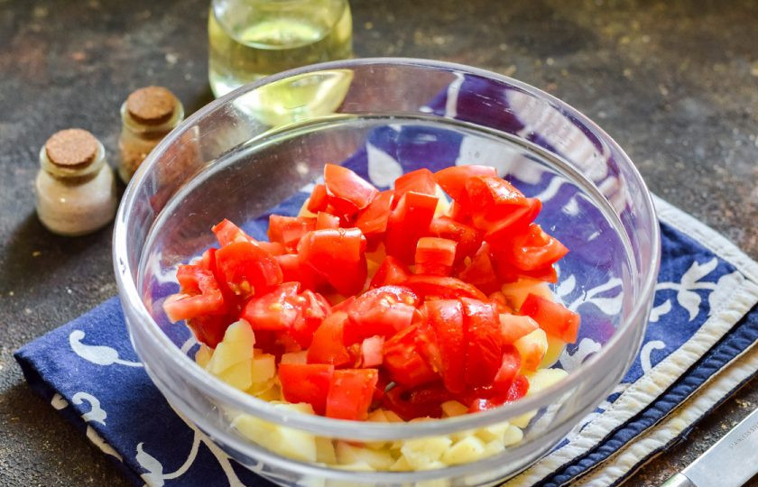 1. Этап. Селянский салат: Далее сполосните и просушите помидоры, удалите место роста плодоножки. Нарежьте помидоры небольшими кубиками и добавьте к картофелю.