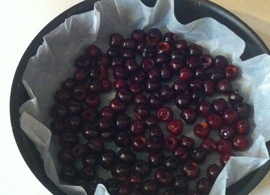 1. Этап. Клафути из черешни: 3. Форму для выпечки покройте бумагой и выложите подготовленные ягоды. Если нет пергамента, то можно смазать форму маслом и обсыпать сахаром.