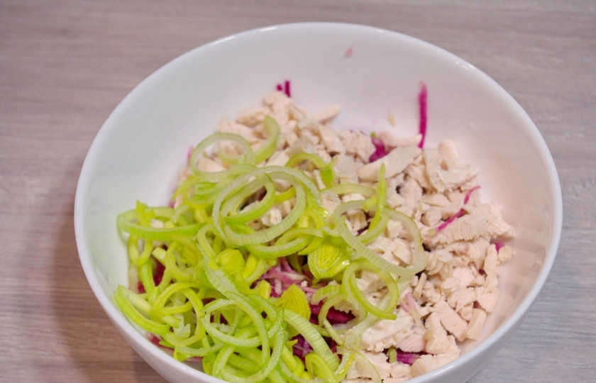 1. Этап. Салат Гнездо на Новый год 2025: Лук порей нарезаем на колечки, тонко. Промойте лук под проточной водой, чтоб смыть весь песок, который может быть внутри ствола лука. Отожмите воду и добавьте лук в салатник.