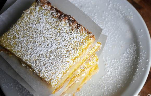 1. Этап. Лимонно-кокосовые пирожные: 6. Дать приготовленному пирогу остыть, нарезать на 12 квадратов, посыпать сахарной пудрой и подавать.