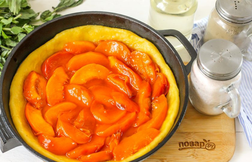 1. Этап. Пирог с персиковым вареньем: Обязательно тесто выложите и на бортики. Затем распределите на тесто персиковое варенье. Лучше всего использовать то, в котором есть фруктовые ломтики — десерт получится очень красочным, аппетитным на вид. Поместите форму с заготовкой в разогретую до 200 градусов духовку и выпекайте примерно 35 минут.