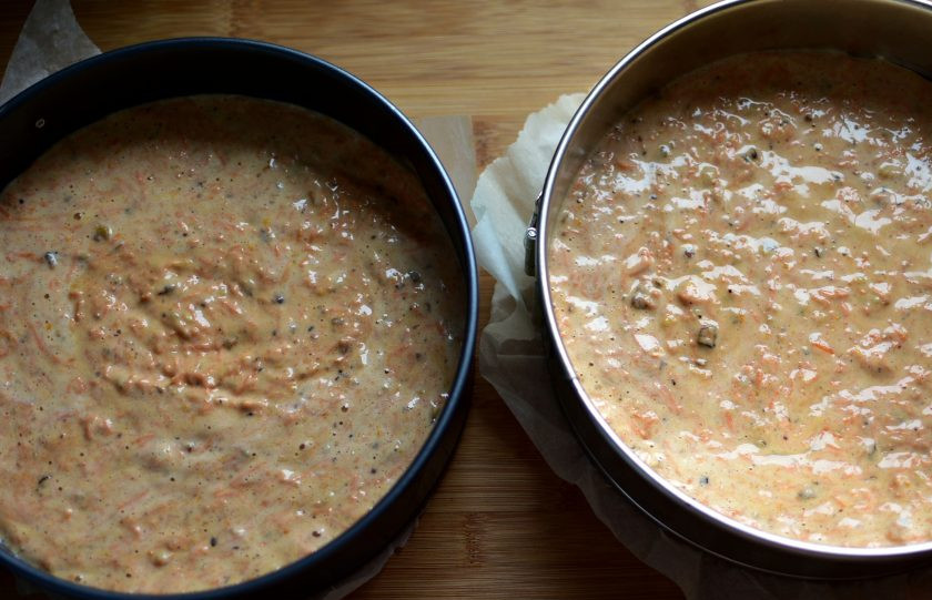 1. Этап. Морковный торт с ароматом апельсина: Разлейте тесто в две одинаковые формы. Дно лучше застелить бумагой для выпечки, а сами формы снаружи обернуть фольгой в два слоя. Такой прием обеспечит ровную поверхность коржей, без бугров посередине. Выпекайте коржи в разогретой до 200 градусов духовке минут 40. Проверьте готовность зубочисткой. Не пересушивайте коржи, ориентируйтесь на вашу духовку. Они должны быть сочными.