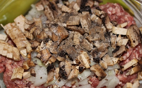 1. Этап. Перец, запеченный с грибами: Шампиньоны промываем и нарезаем тонкими пластинками. Добавляем к фаршу. Солим и перчим по вкусу.