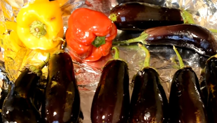 1. Этап. Самая вкусная баклажанная икра Сырая: 1. Противень застилаем фольгой и смазываем подсолнечным маслом. Баклажаны и перец моем и вытираем насухо, затем выкладываем на противень. Каждый овощ смазываем растительным маслом и прокалываем вилкой. Накрываем овощи фольгой, выпекаем при 160 градусах около 40-50 минут.