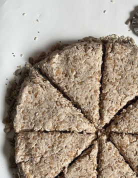 1. Этап. Гречневые уголки: Выложить тесто на семечки, разровнять ложкой или силиконовой лопаткой, сформировать круг толщиной около 2 см. Нарезать на 8 уголков.