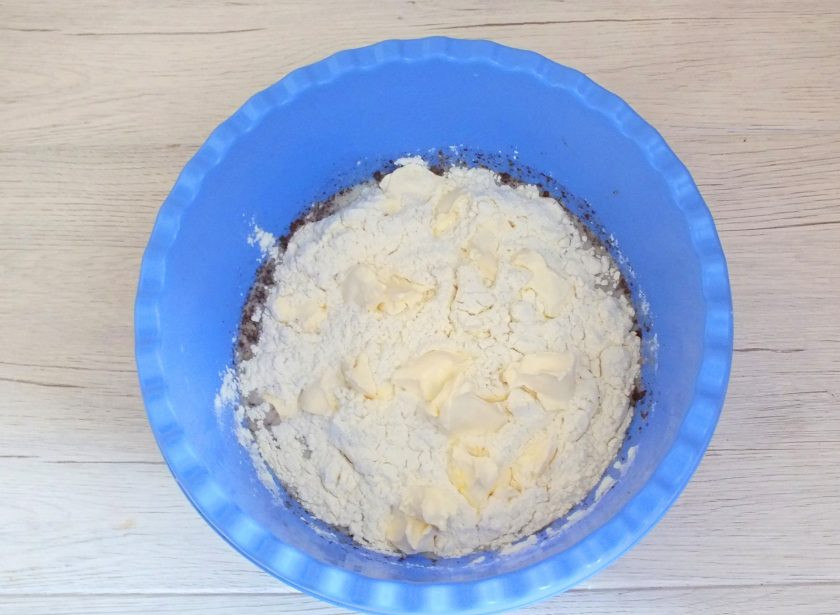 1. Этап. Булочки Даллас: Всыпьте часть муки, добавьте 75 грамм мягкого сливочного масла. Перемешайте ложкой. Всыпьте еще муку и начните замес теста руками.