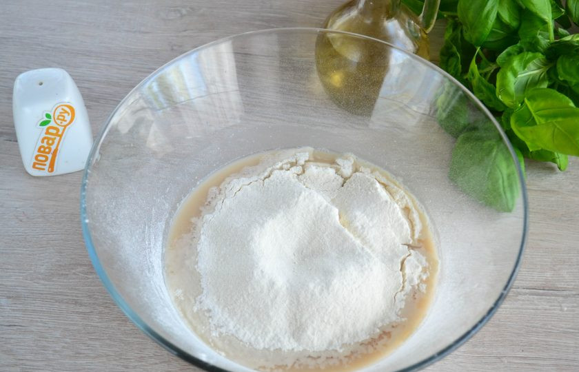 1. Этап. Пицца Каприччиозо: Добавьте несколько столовых ложек растительного масла (лучше добавлять оливковое масло), просейте муку и замесите тесто.