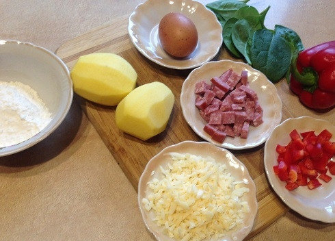 1. Этап. Картофельная пицца на сковороде: Подготовим ингредиенты. Очистим картофель, помоем и высушим листья шпината. Нарежем на кубики колбасу и болгарский перец. Сыр натираем на терке.