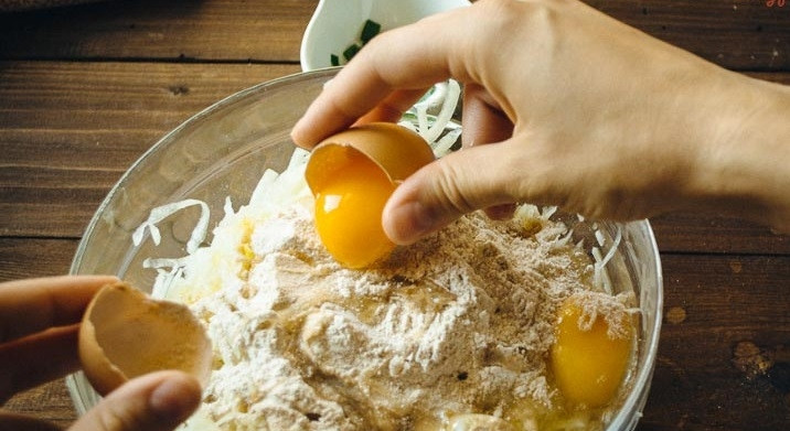 1. Этап. Сырная запеканка в духовке: 3. В миску кладем отжатый кабачок, добавляем половину сыра, всыпаем муку, зелень, соду и соль, вбиваем яйца и тщательно перемешиваем.