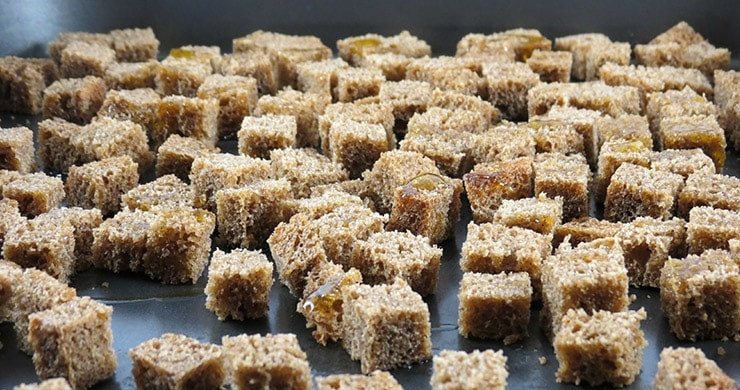 1. Этап. Цезарь со свининой: Для приготовления сухариков порежьте хлеб на кубики, чем ровнее они будут, тем лучше. Положите хлеб на противень и поставьте его в духовку, разогретую до 200 градусов, на 10-15 минут. Можно посыпать сухарики солью и перцем.