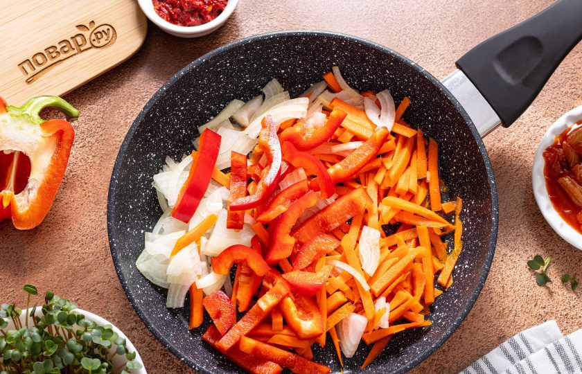 1. Этап. Токпокки с кимчи: Морковь очистите и порежьте брусочками, либо натрите на терке для моркови по-корейски. Репчатый лук порежьте полукольцами, а болгарский перец полосками. Обжарьте овощи в сковороде на среднем огне 2-3 минуты до мягкости и легкого золотистого цвета.