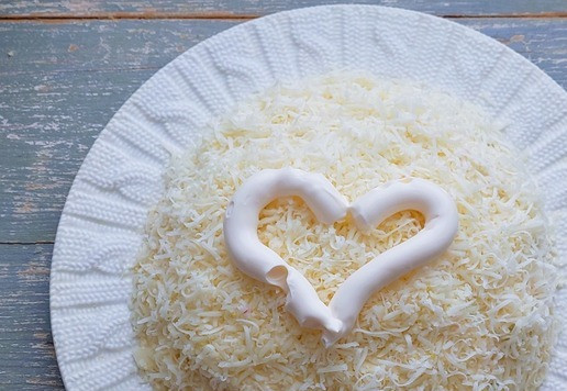 1. Этап. Салат с тунцом Новогодний шар: Затем натереть сыр на мелкой тёрке, смазать майонезом.