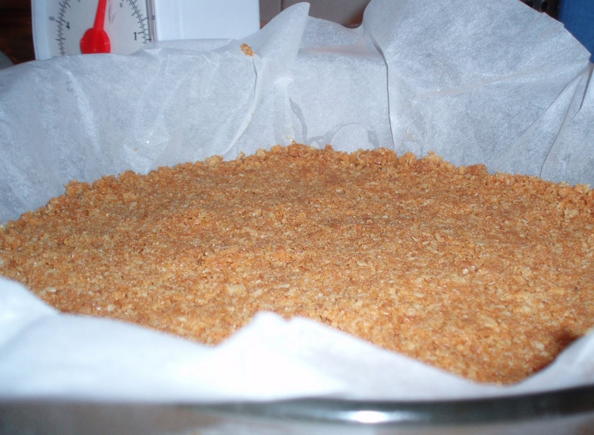 1. Этап. Творожный пирог Нежность: 1. Печенье перетираем в крошку вместе с растопленным сливочным маслом. Выкладываем эту массу на дно формы, утрамбовывая.