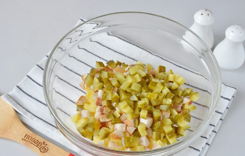 1. Этап. Салат с копченой рыбой: Огурчик нарежьте кубиками.