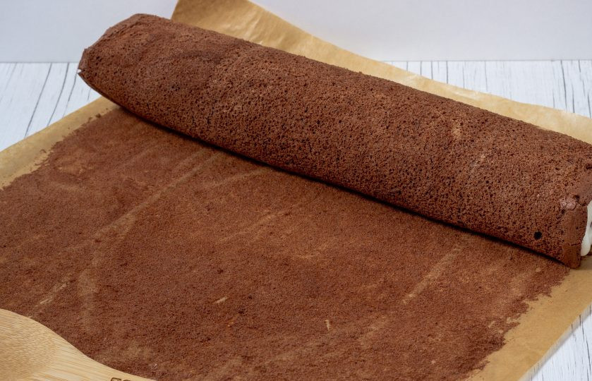 1. Этап. Шоколадный бисквитный рулет: Аккуратно снимая с бумаги, снова заверните в рулет вместе с кремом.