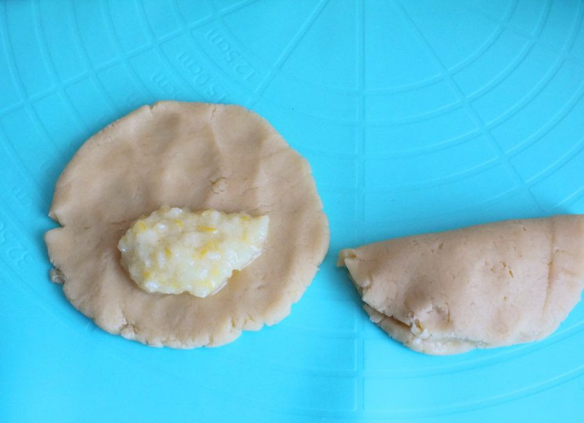 1. Этап. Печенье с лимонной начинкой: На одну половину заготовки-лепешки положите 1/2 ч.л. лимонной начинки (больше начинки класть не стоит, в противном случае она вытечет и подгорит), закройте второй половинкой теста и слегка прижмите края печенья. Проделайте этот процесс с остальными заготовками. Подготовленное печенье переложите на противень застеленный бумагой и выпекайте в разогретой до 180 градусов духовке 12-15 минут.