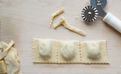 1. Этап. Постные равиоли: Накрываем начинку второй половиной теста. Скрепляем сначала бока, выдавливаем воздух в промежутках между начинкой, прижимаем длинный край пласта теста. Затем фигурным ножом разрезаем равиоли и ровняем края. Края равиоли можно придавить зубчиками вилки: и красиво, и точно не расклеятся.