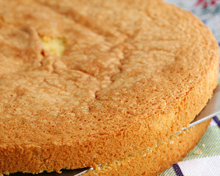 1. Этап. Бисквитный торт с творогом: Бисквитное тесто выливаем в смазанную маслом форму, осторожно выравнивая по поверхности. Ставим выпекаться в духовку при температуре 180 градусов на полчаса. Готовность проверяем спичкой или шпажкой. Готовый корж переворачиваем вверх дном и ставим остывать в таком положении, не вытаскивая из формы. Затем разрезаем корж острым ножом и получаем 2 коржа.