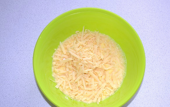 1. Этап. Запеканка из макарон с брокколи: Взбейте до однородности и добавьте половину тертого сыра.