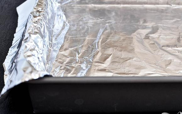 1. Этап. Шоколадные пирожные со сливочной начинкой: 1. Разогреть духовку до 160 градусов. Выстелить форму для выпечки фольгой, оставляя 5-сантиметровый навес с двух сторон, сбрызнуть маслом.