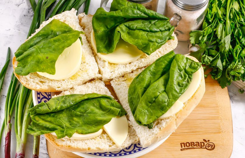 1. Этап. Панини с помидорами и моцареллой: Промойте листья шпината и выложите поверх моцареллы. Допустимо заменить свежий шпинат базиликом, но только зеленого цвета.