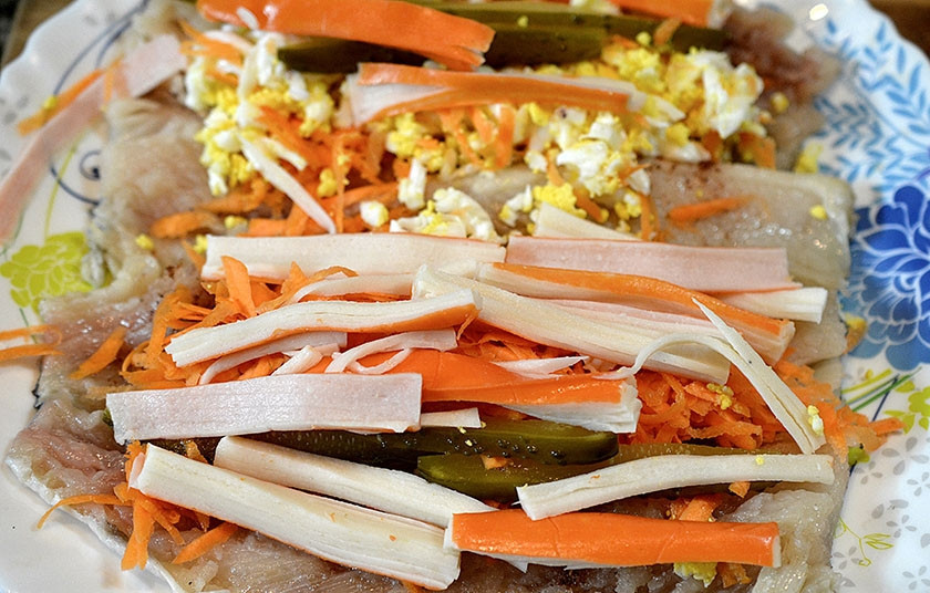 1. Этап. Рулет из рыбы с овощами: 3. На начинку выложите нарезанные соломкой крабовые палочки.